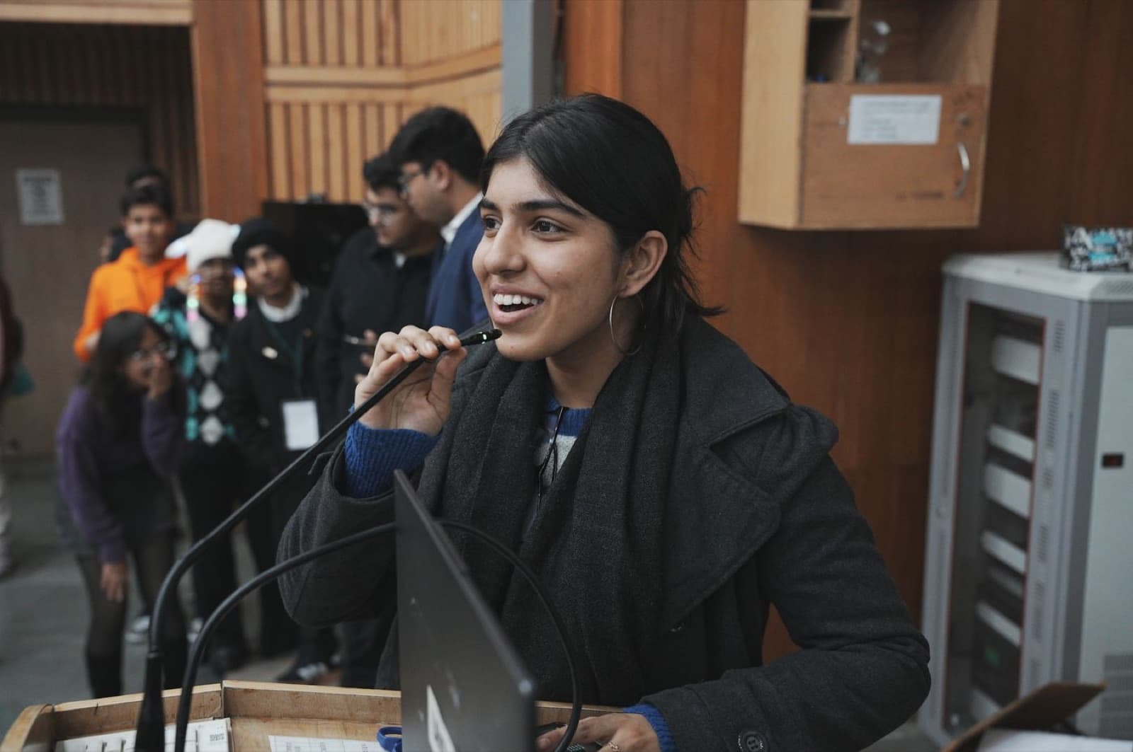 A student smiling at the microphone as she presents to the room