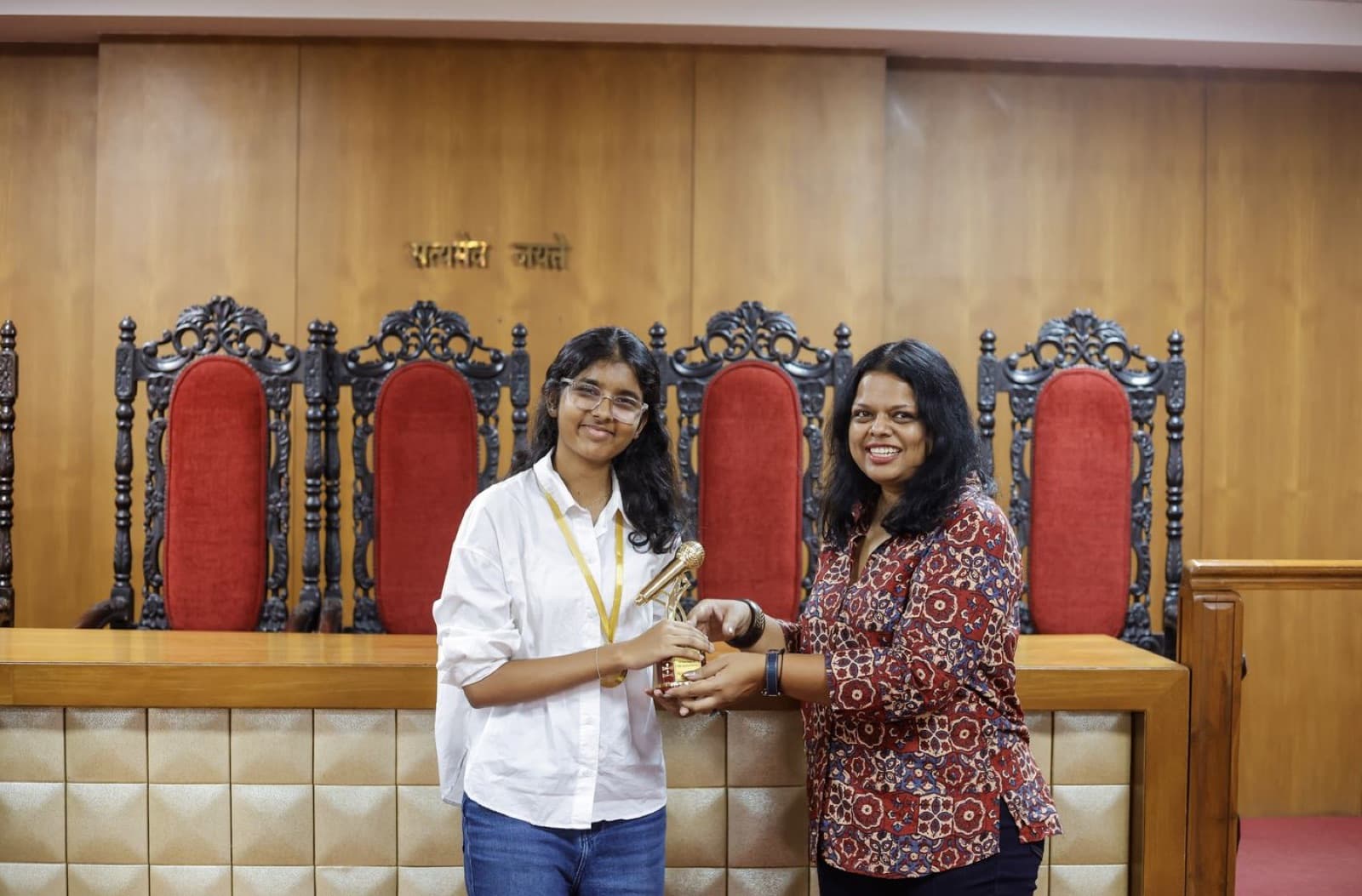 A coach handing a trophy to a student