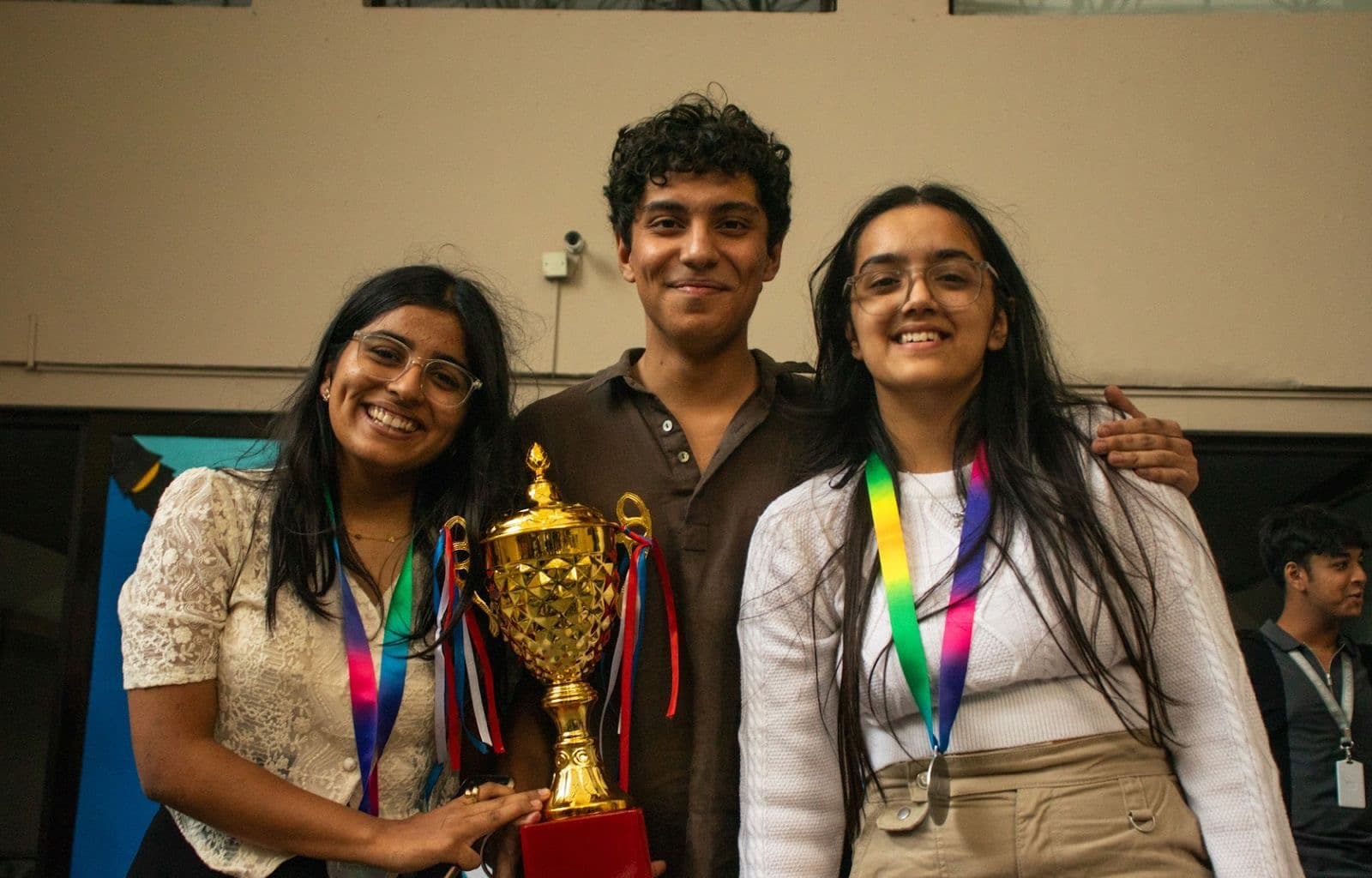 Three students holding a trophy after a final